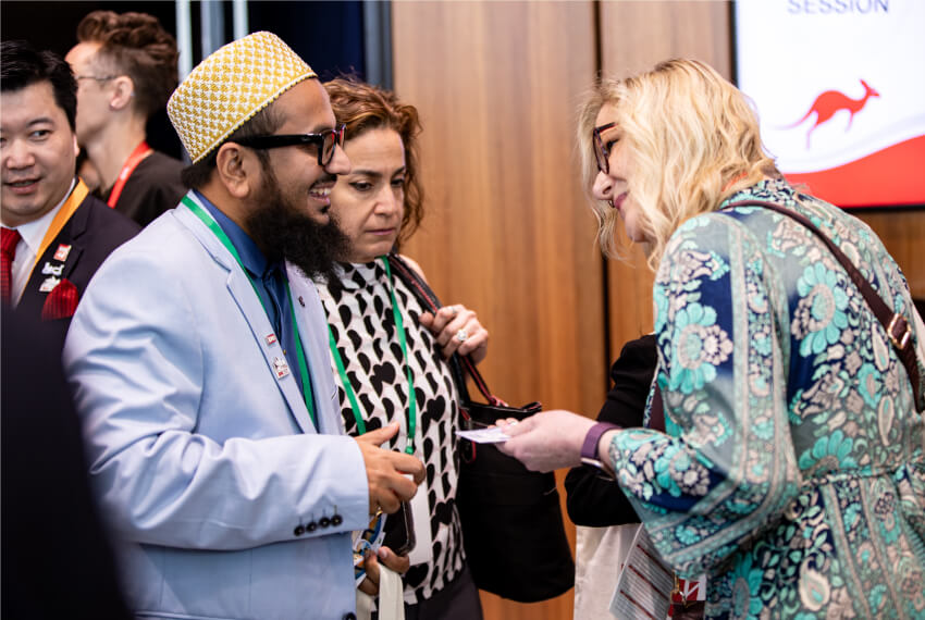 Three professionals exchanging business cards and networking at a BNI event